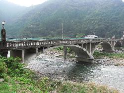 山間の川に渡された、大きなアーチ状の若桜橋の写真