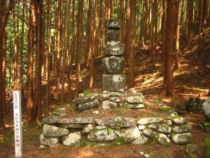木立の中で、石の台座の上に建つ長砂与五郎の五輪塔の写真