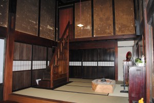 畳張りの部屋の中に2階部分へと続く階段がある木島家住宅主屋の中の写真