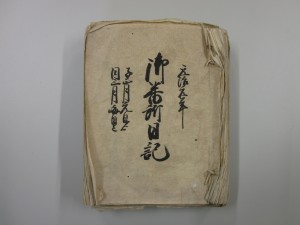 色あせて、紙の端が反り返っている浅井御番所日記の表紙の写真