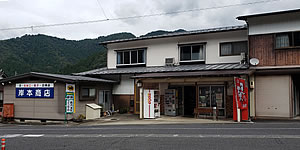 岸本商店の建物外観の写真。建物に青い看板が掛かっている。