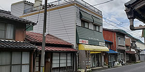 フードセンター小嶋の建物外観の写真。黄色い軒が見える。