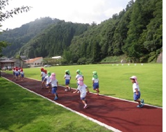 八幡広場敷地内のウォーキングコースを走る幼児たちの写真