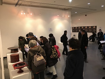 漆工芸センターの展示物を見学する複数人の写真